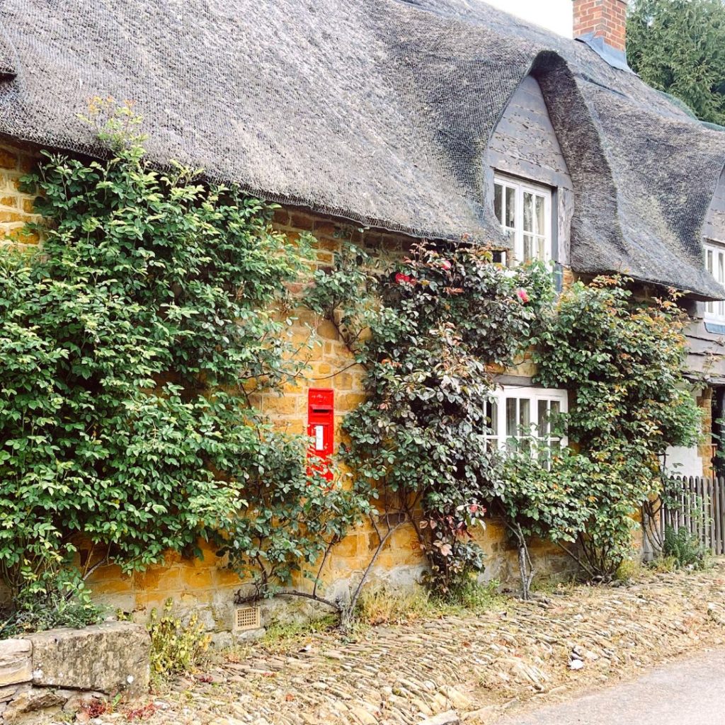 A cottage with a post box in an article about interesting facts about northamptonshire.