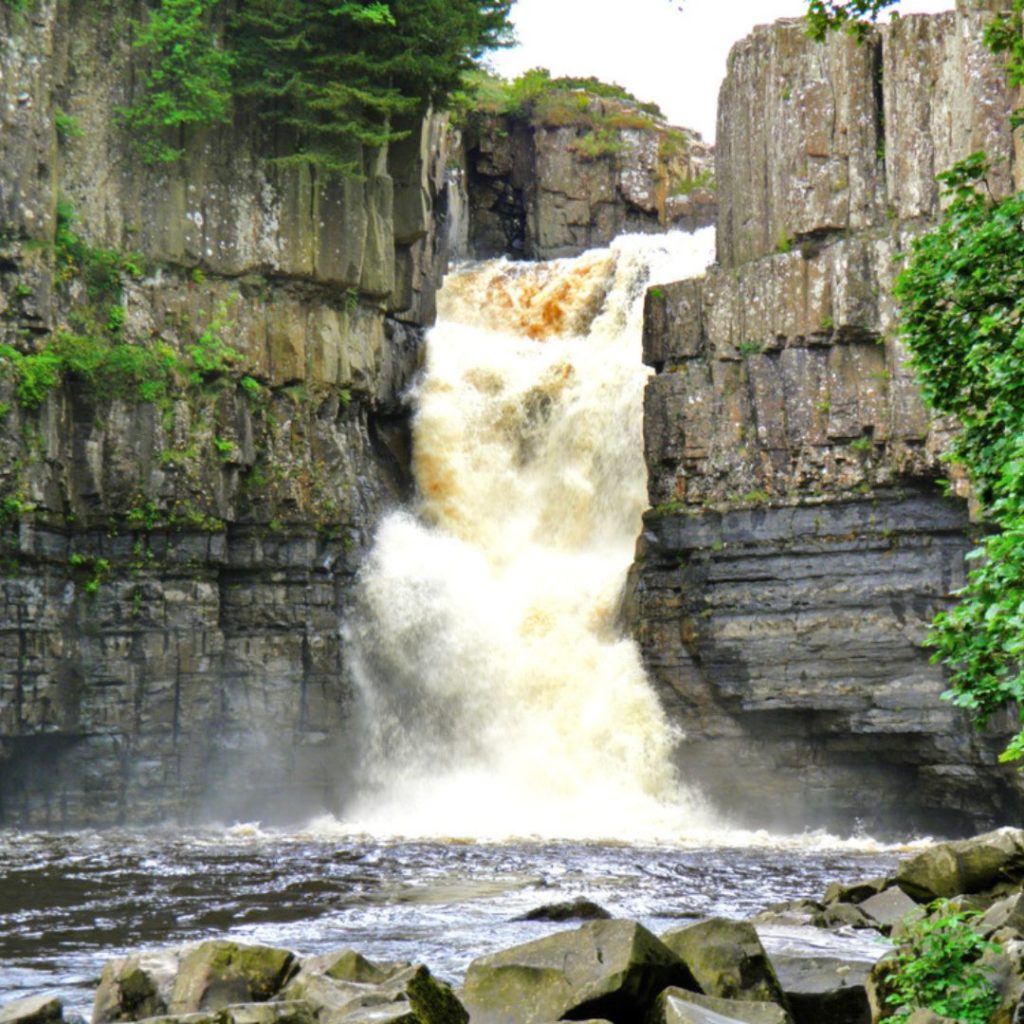 Visiting this waterfall is one of the tghings to do in England. The picture shows water cascading over two cliffs.