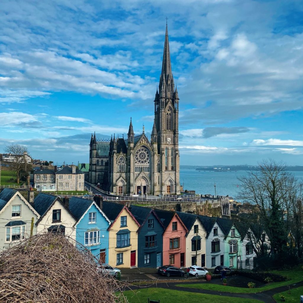 colourful houses on a hill with a church behind